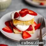 A strawberry shortcake on a plate topped with whipped cream and berries.