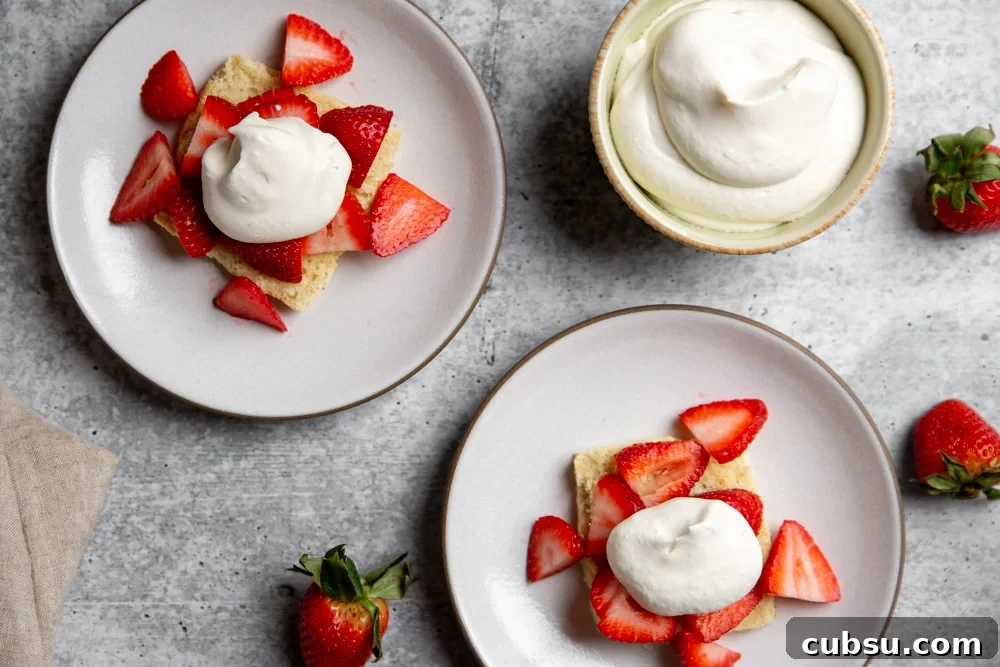 gluten-free Strawberry shortcakes on plates topped with sliced strawberries and whipped cream. 