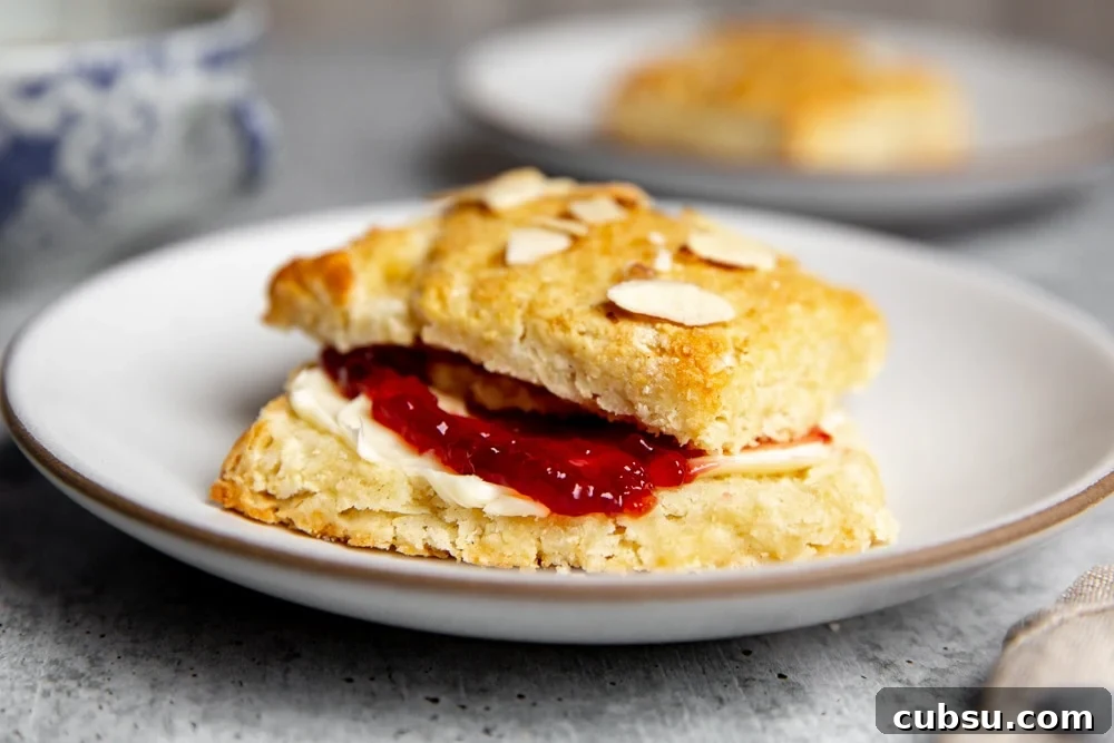 An almond shortcake on a plate filled with butter and jam. 