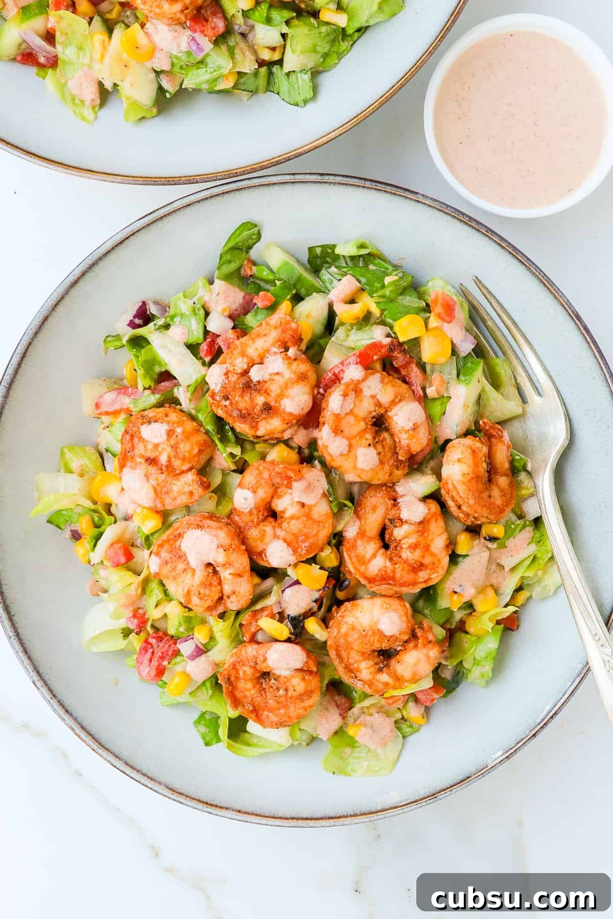 Zesty Cajun Shrimp Salad with Avocado and Lime Dressing 2 Cajun shrimp salad served in a bowl with extra dressing.