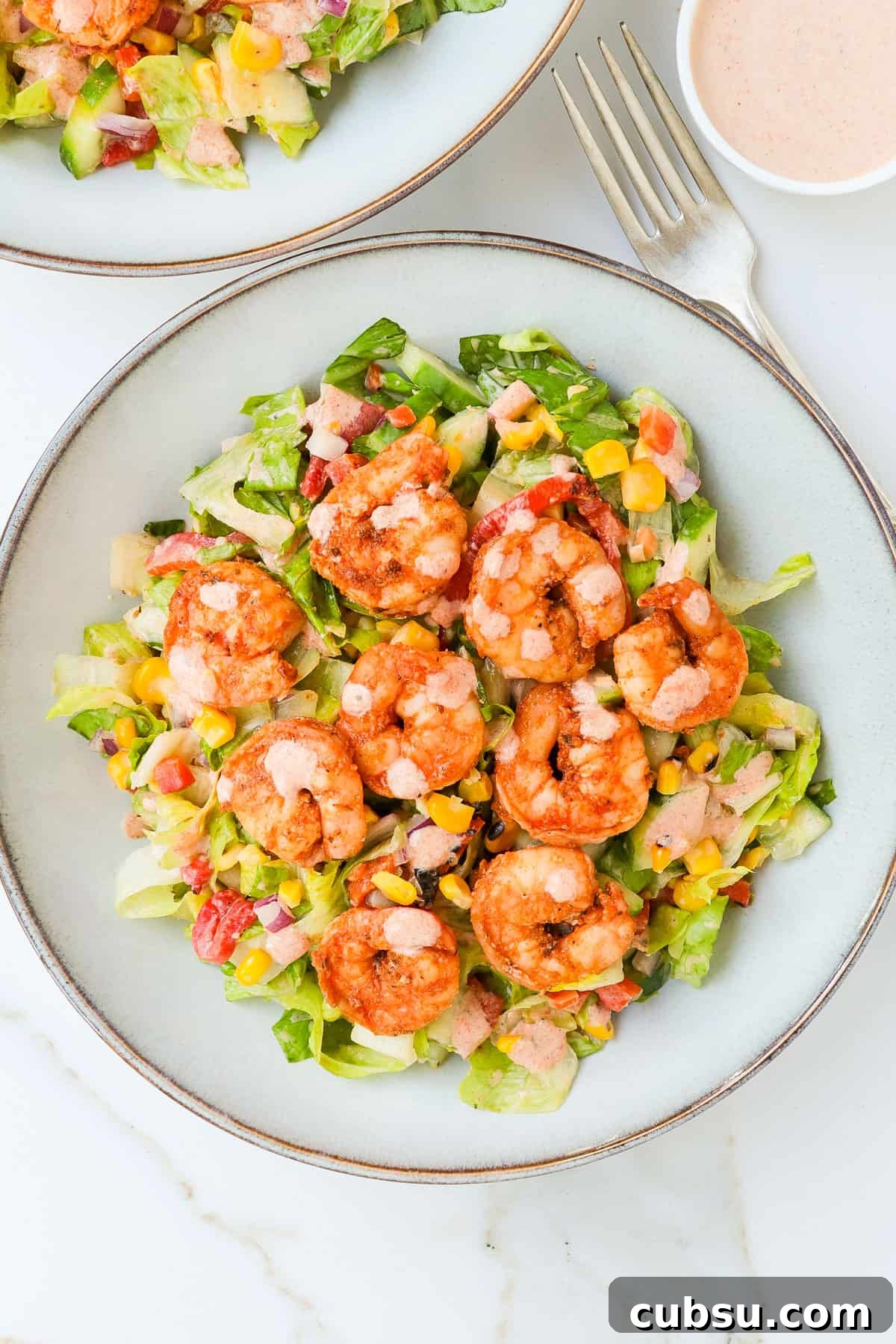 Zesty Cajun Shrimp Salad with Avocado and Lime Dressing 11 Cajun shrimp salad served in bowls with extra dressing on the side.