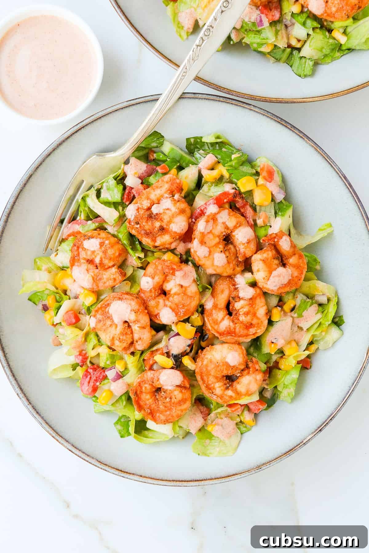 Zesty Cajun Shrimp Salad with Avocado and Lime Dressing 3 Cajun shrimp salad in a bowl with and fork.