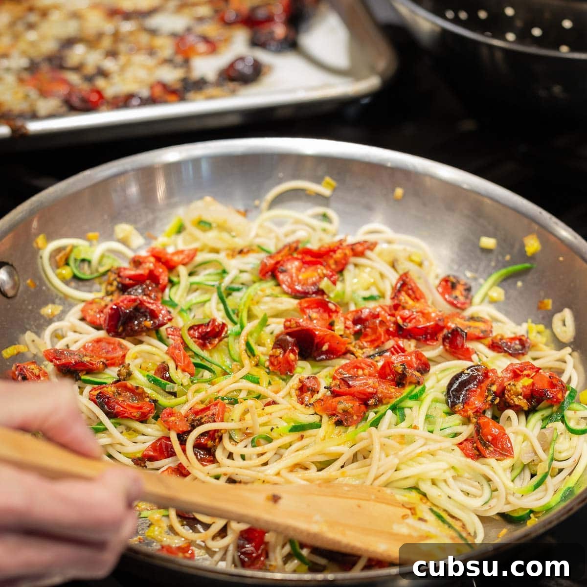 A pan of zucchini noddles and past noodles with roasted tomatoes.