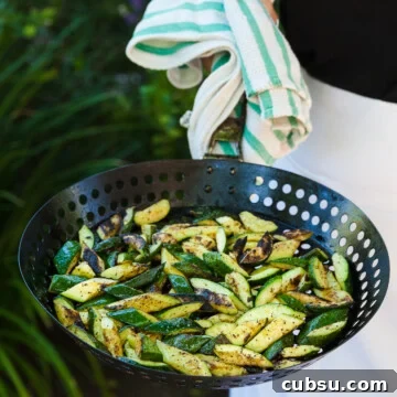 Grilled zucchini in a grill basket right off the barbecue.