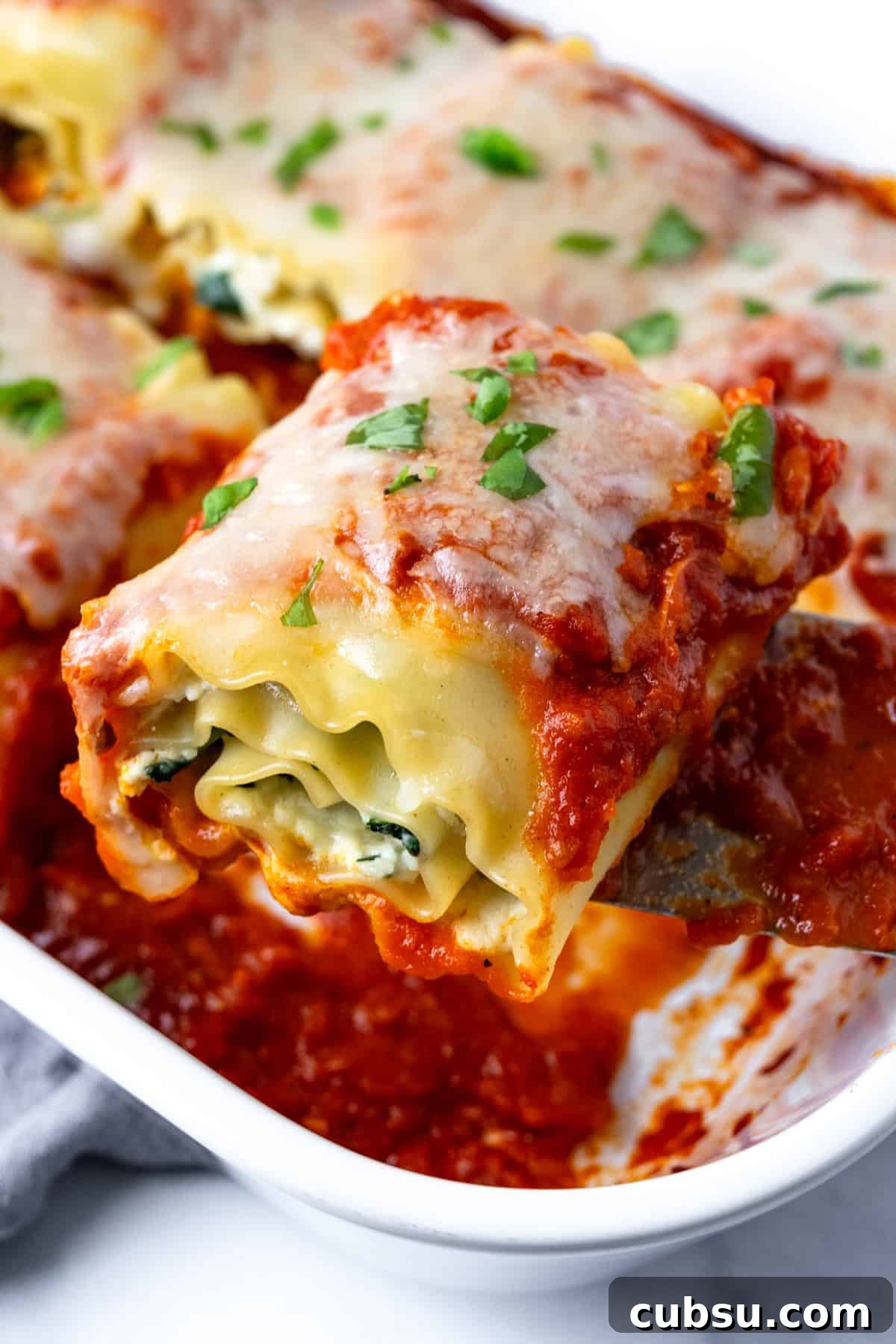 Cheesy Spinach Lasagna Rolls with Ricotta Filling 5 A spatula serving a Spinach Lasagna Roll.
