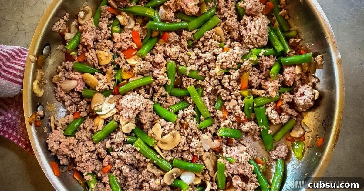 Ground beef and vegetables in a skillet.