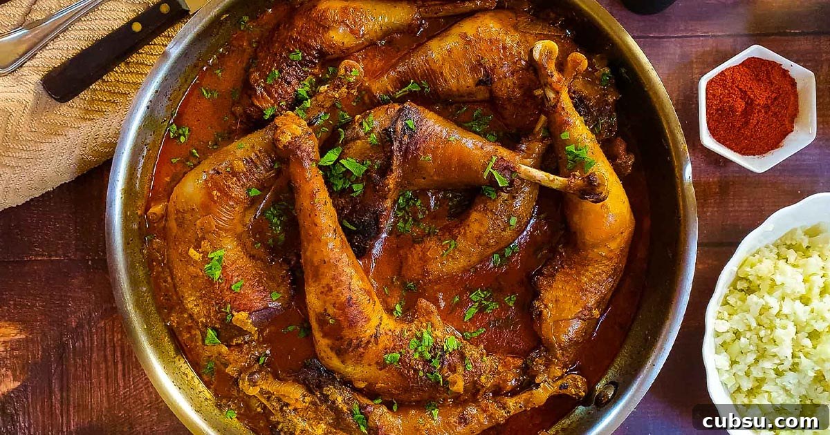 Braised chicken legs in a red paprika sauce.