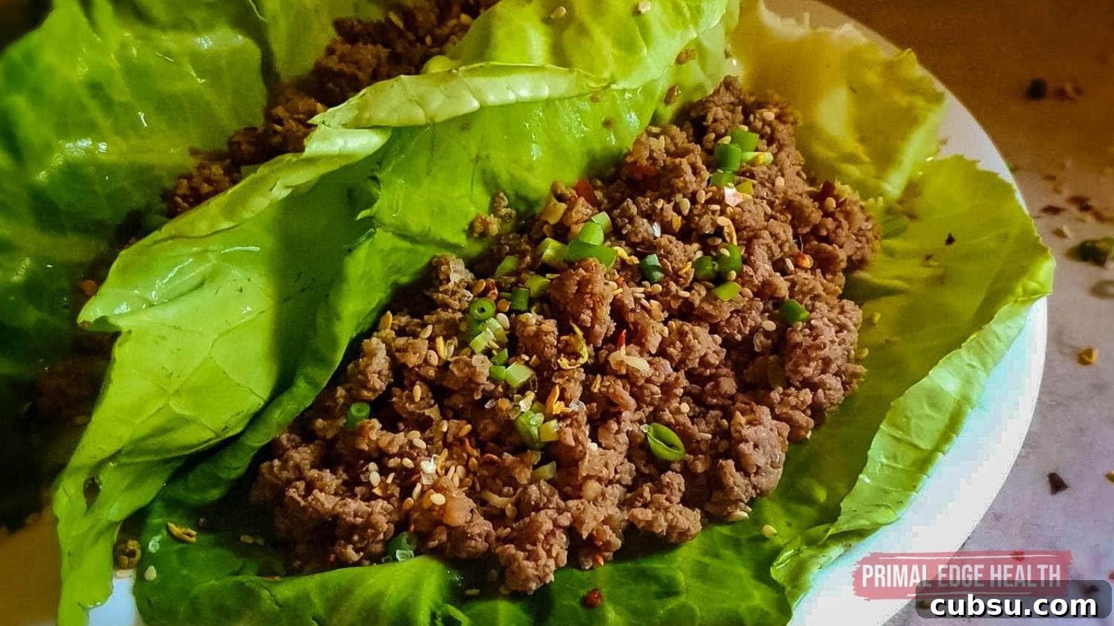 Lettuce wraps filled with seasoned ground beef and garnished with chopped green onions.