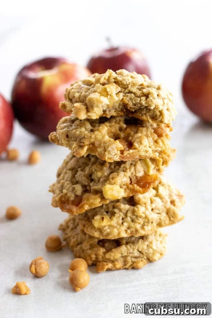 caramel apple oatmeal cookies in a stack with fresh apples behind