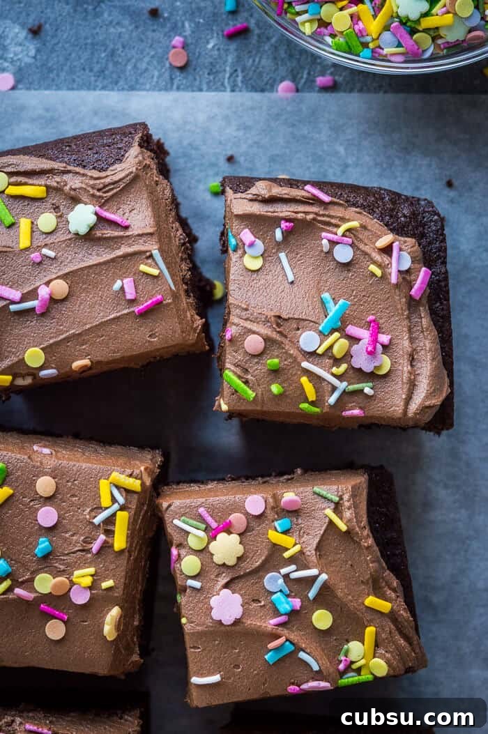 Decadent Vegan Chocolate Cake Recipe: Moist, Dairy-Free Slice 9 close up of squares of easy vegan chocolate cake on a sheet of baking parchment.