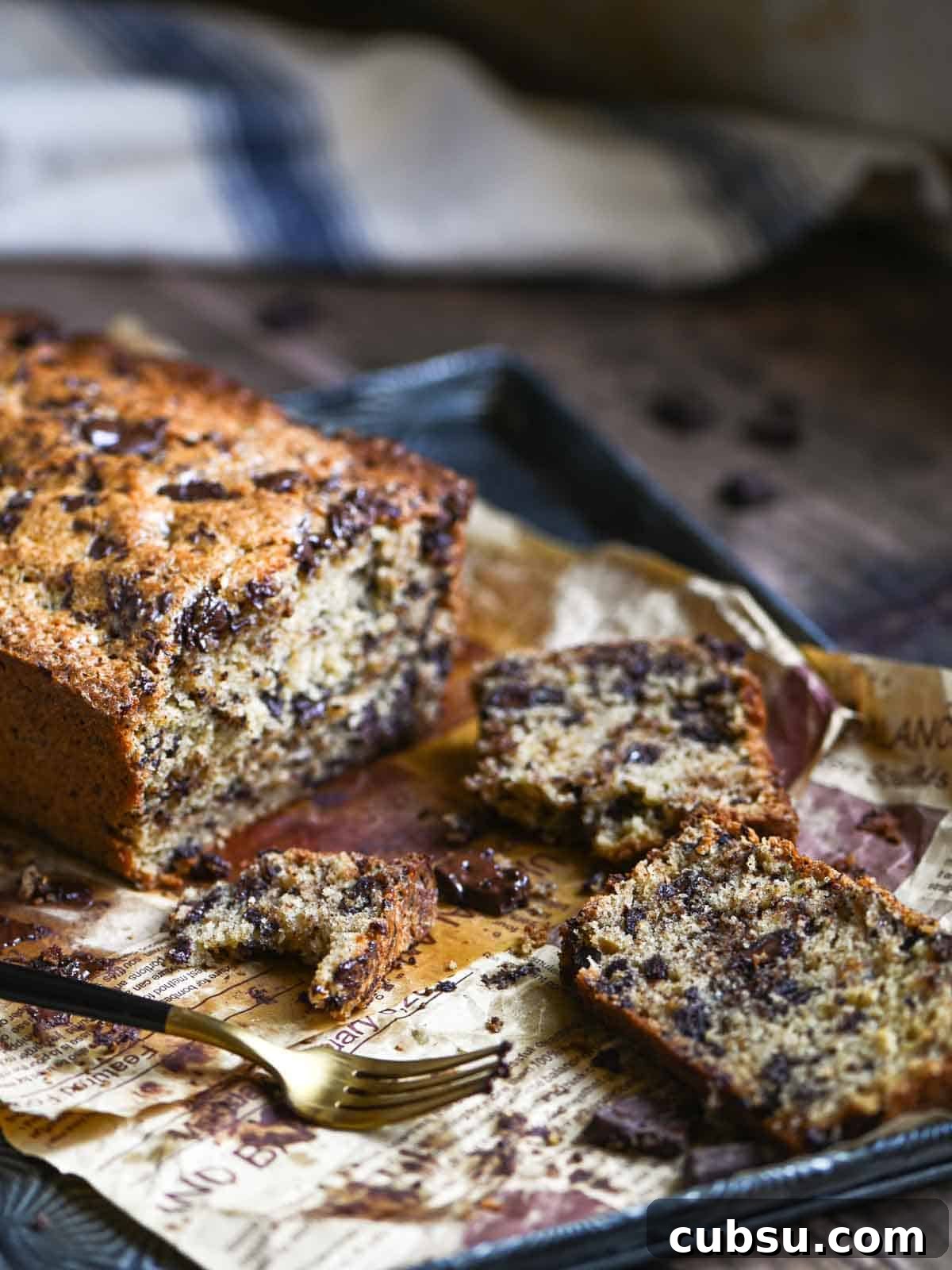 Slices of chocolate chip loaf cake sliced on a tray with a fork.