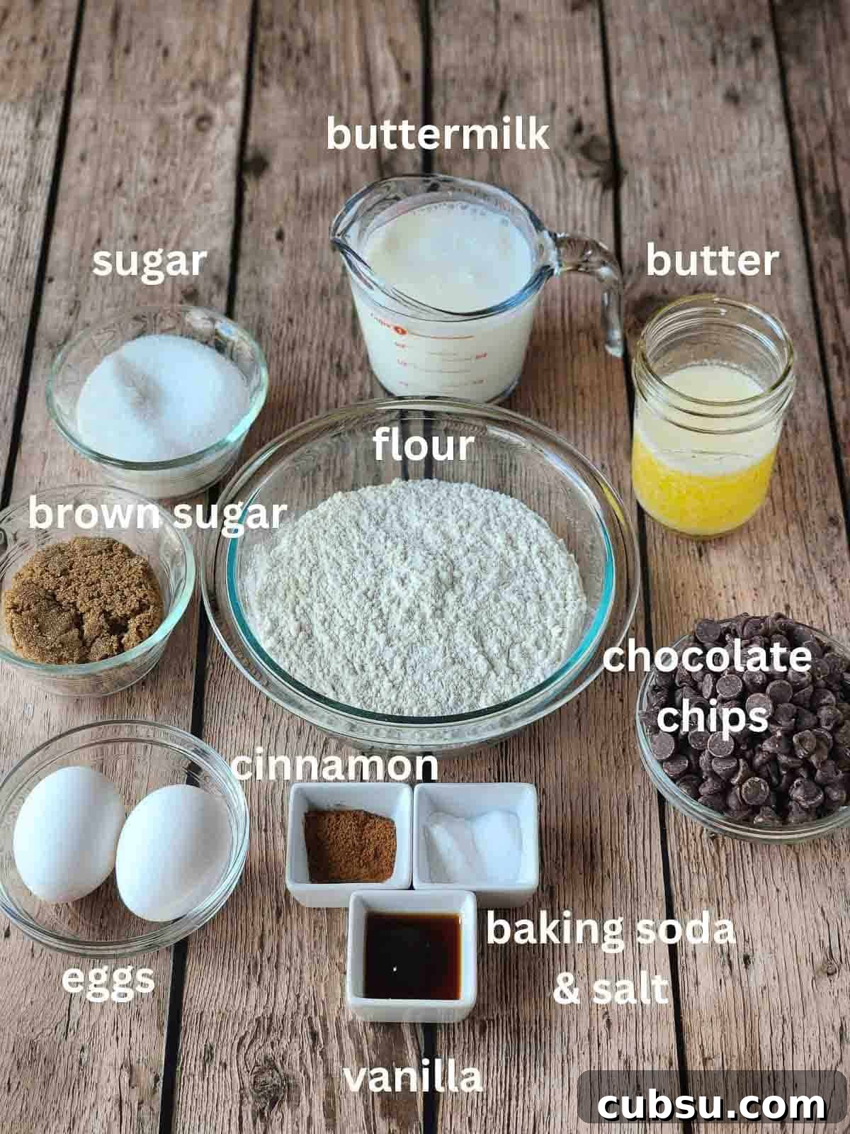 Labeled ingredients for a cake on a wood surface.