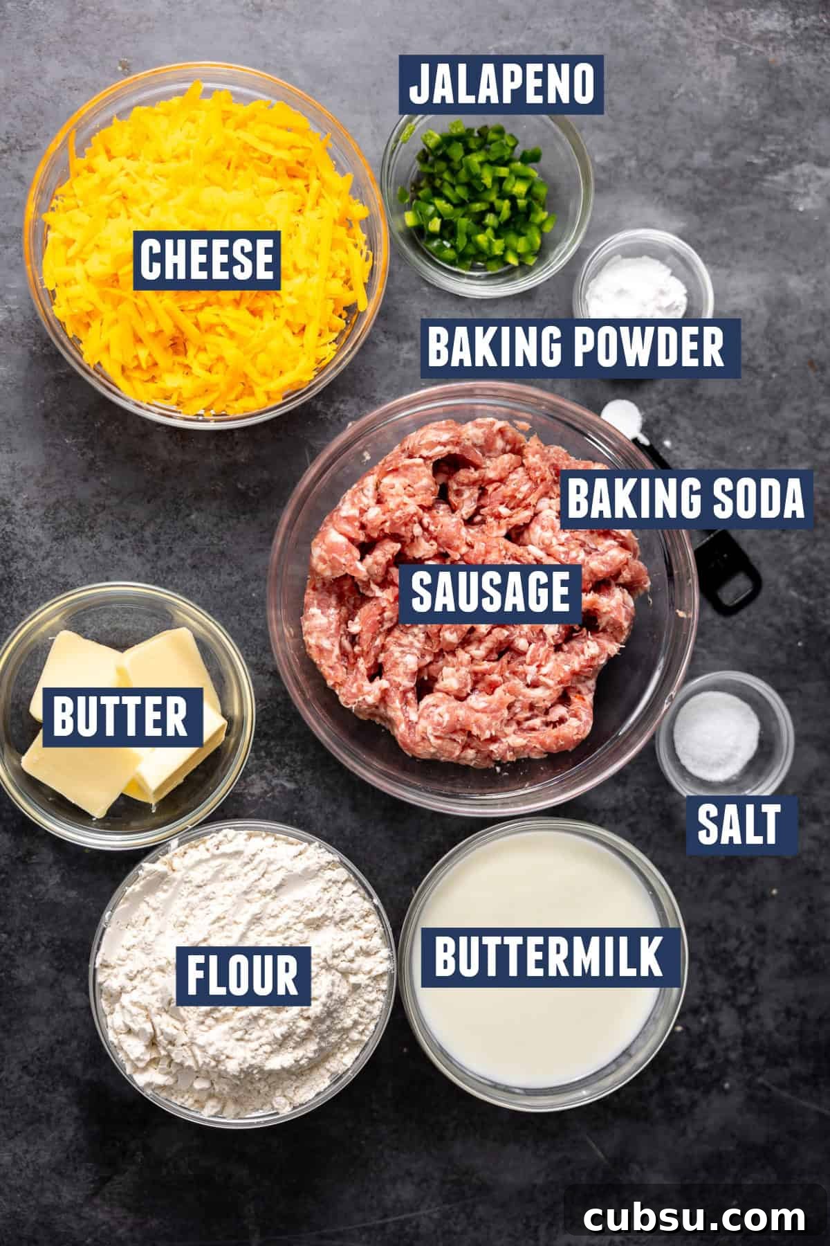 Cheesy Sausage Biscuit Recipe — Flaky Savory Breakfast Biscuits 5 Ingredients needed to make cheese and sausage biscuits including: flour, sausage, cheese, jalapeno, baking powder, baking soda, salt, buttermilk, and butter.