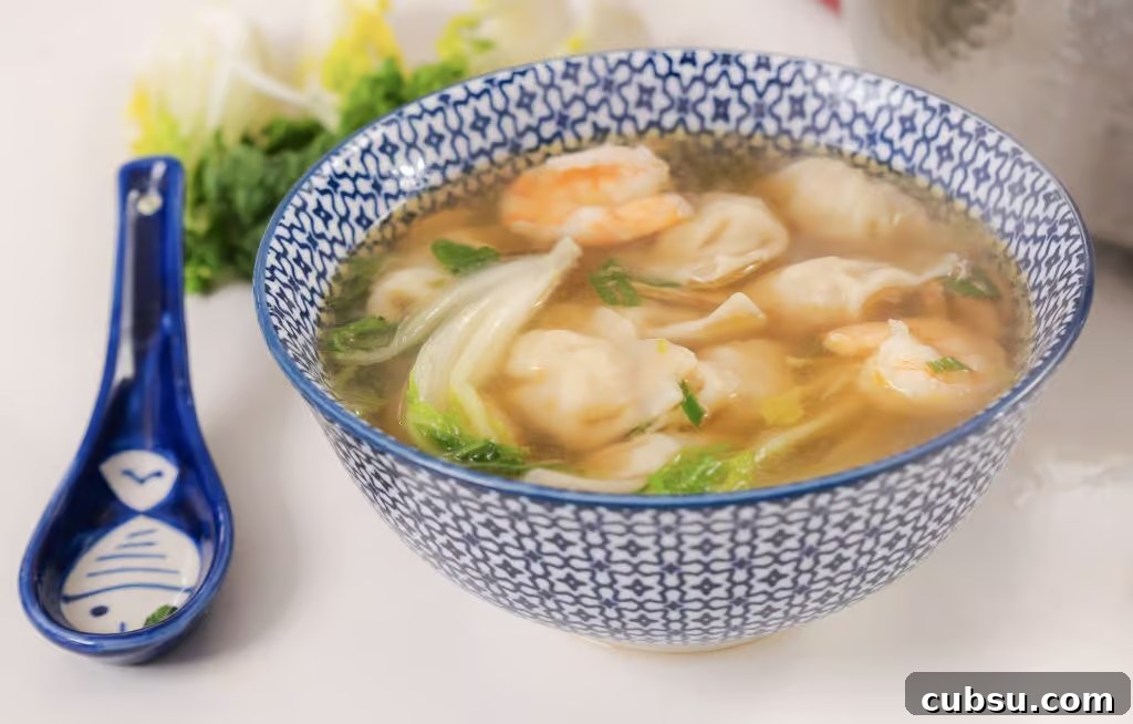 Authentic Homemade Wonton Soup Recipe with Savory Broth 2 Homemade Wonton Soup in a white and blue china bowl.