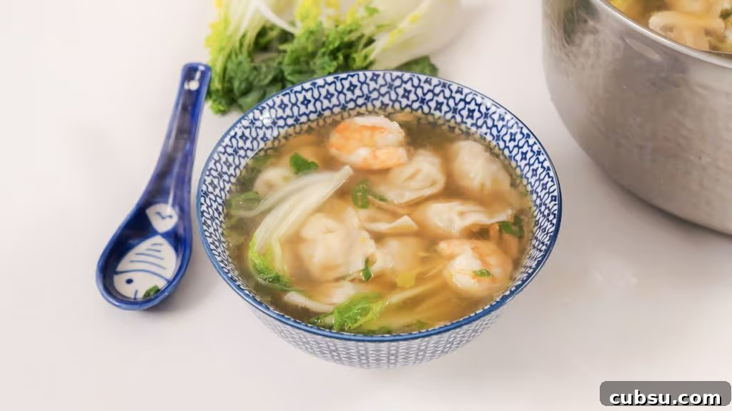 Authentic Homemade Wonton Soup Recipe with Savory Broth 3 Homemade Wonton Soup in a white and blue china bowl.