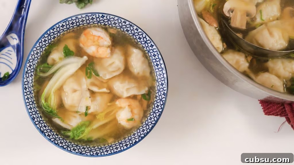 Authentic Homemade Wonton Soup Recipe with Savory Broth 4 Homemade Wonton Soup in a white and blue china bowl.