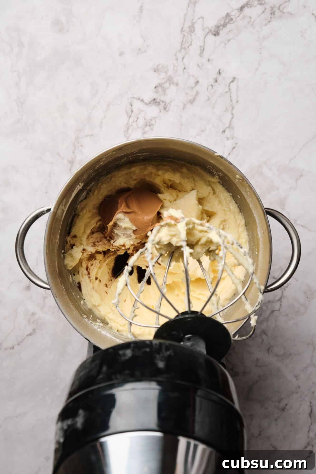 Chocolate Cake with Creamy Peanut Butter Frosting Recipe 10 Peanut butter buttercream being blended in a mixer.