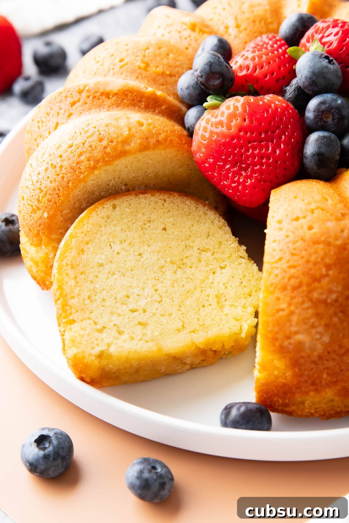 Classic Buttermilk Pound Cake Recipe with Tender Crumb 3 One slice of this buttermilk pound cake recipe sitting on a platter with the whole cake to show the buttery, light yet dense tender crumb.