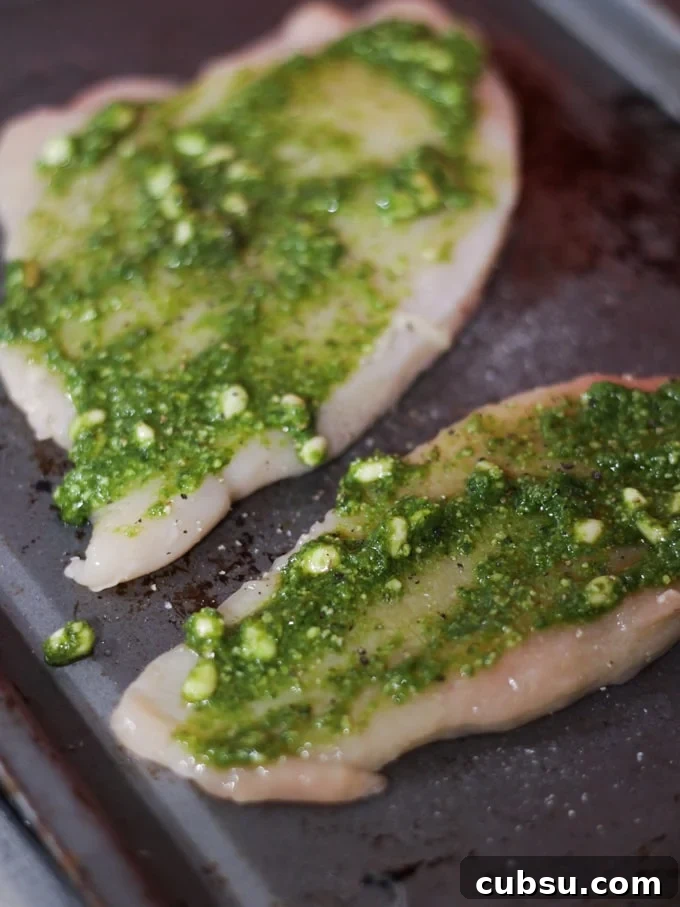 raw meat with herb paste on a baking tray