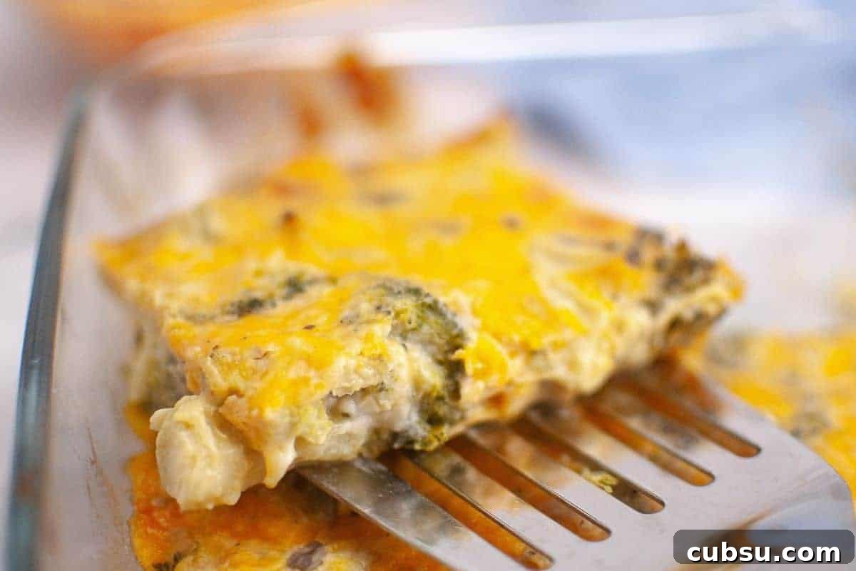 31 Classic Comfort Recipes That Keep Families Coming Back 12 A metal spatula lifts a slice of 3-Ingredient Broccoli Cheese Casserole from a glass baking dish.