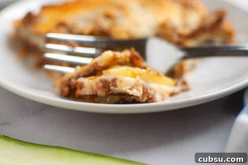 31 Classic Comfort Recipes That Keep Families Coming Back 15 A close-up, slightly high-angle view of Zucchini Lasagna squares arranged on a dark gray baking sheet, each topped with a glossy, light brown apple filling and a generous sprinkle of light brown crumb topping.