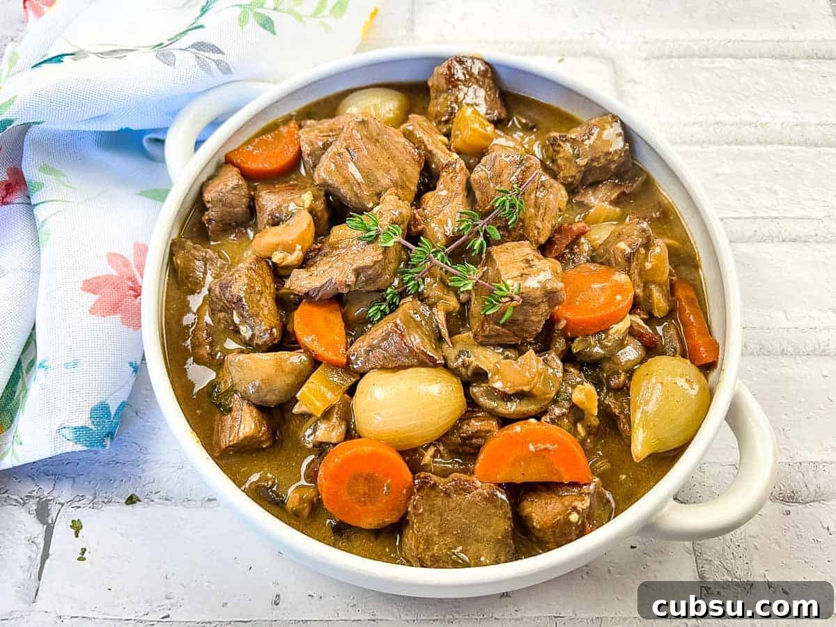 31 Classic Comfort Recipes That Keep Families Coming Back 26 Beef bourguignon in a white bowl with thyme.