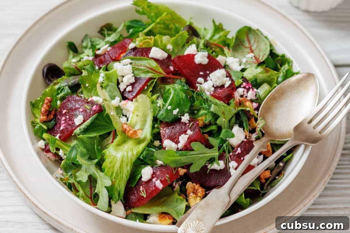 31 Classic Comfort Recipes That Keep Families Coming Back 9 A plate of Beet Salad with Goat Cheese & Walnuts, served with a fork and spoon on the side.