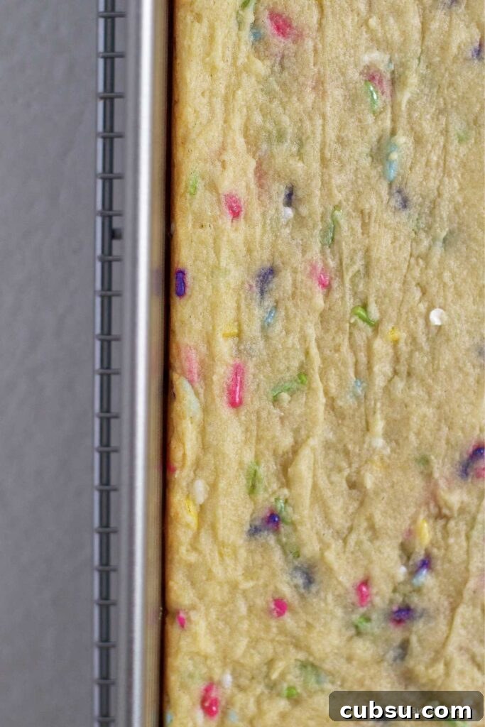 Cream Cheese Sugar Cookie Bars — Soft Frosted Dessert Bars 11 baked sugar cookie bars showing barely browned edges