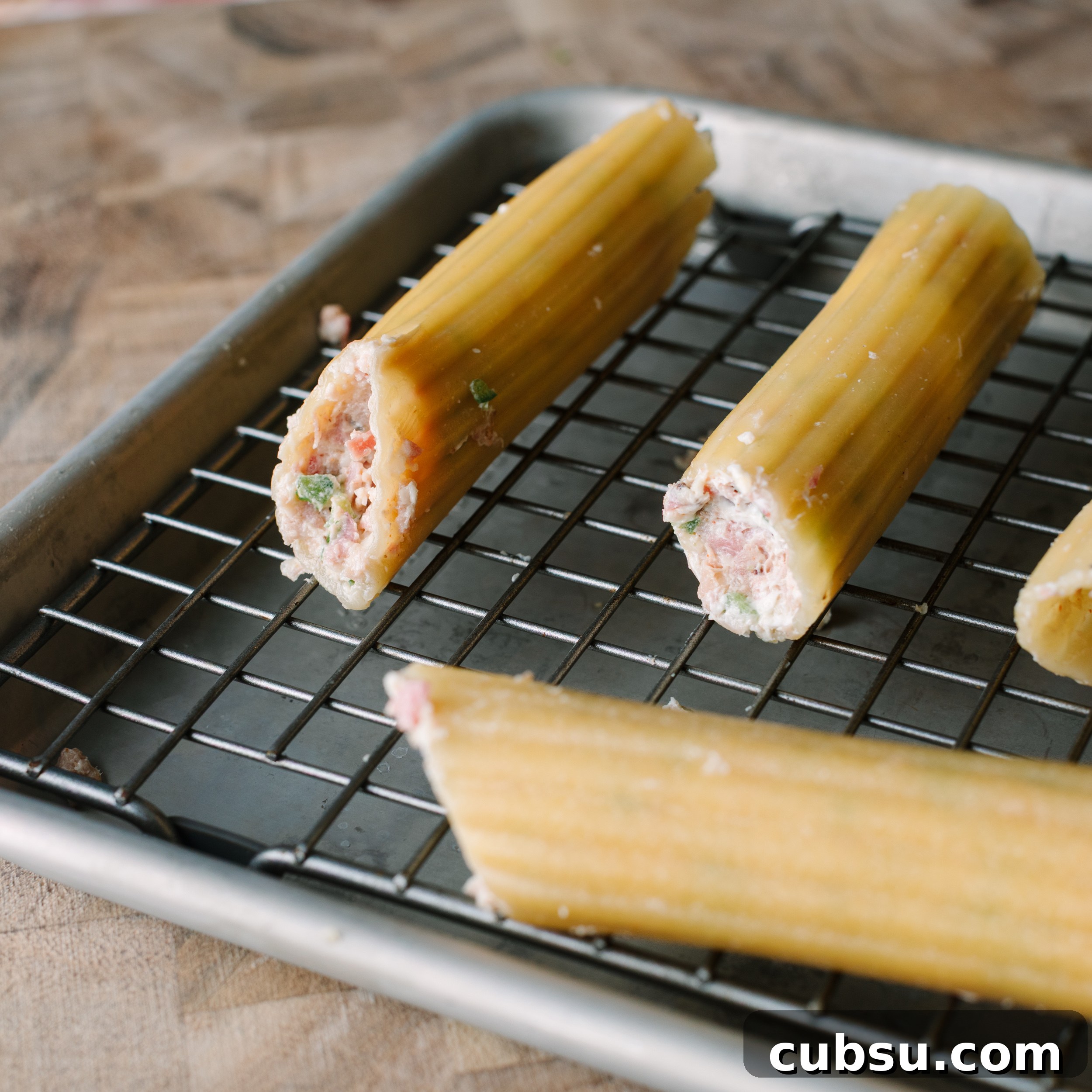 Smoked Shotgun Shells: How They're Made and What to Know 6 Stuffed cannelloni shells on a wire rack set over a sheet pan.