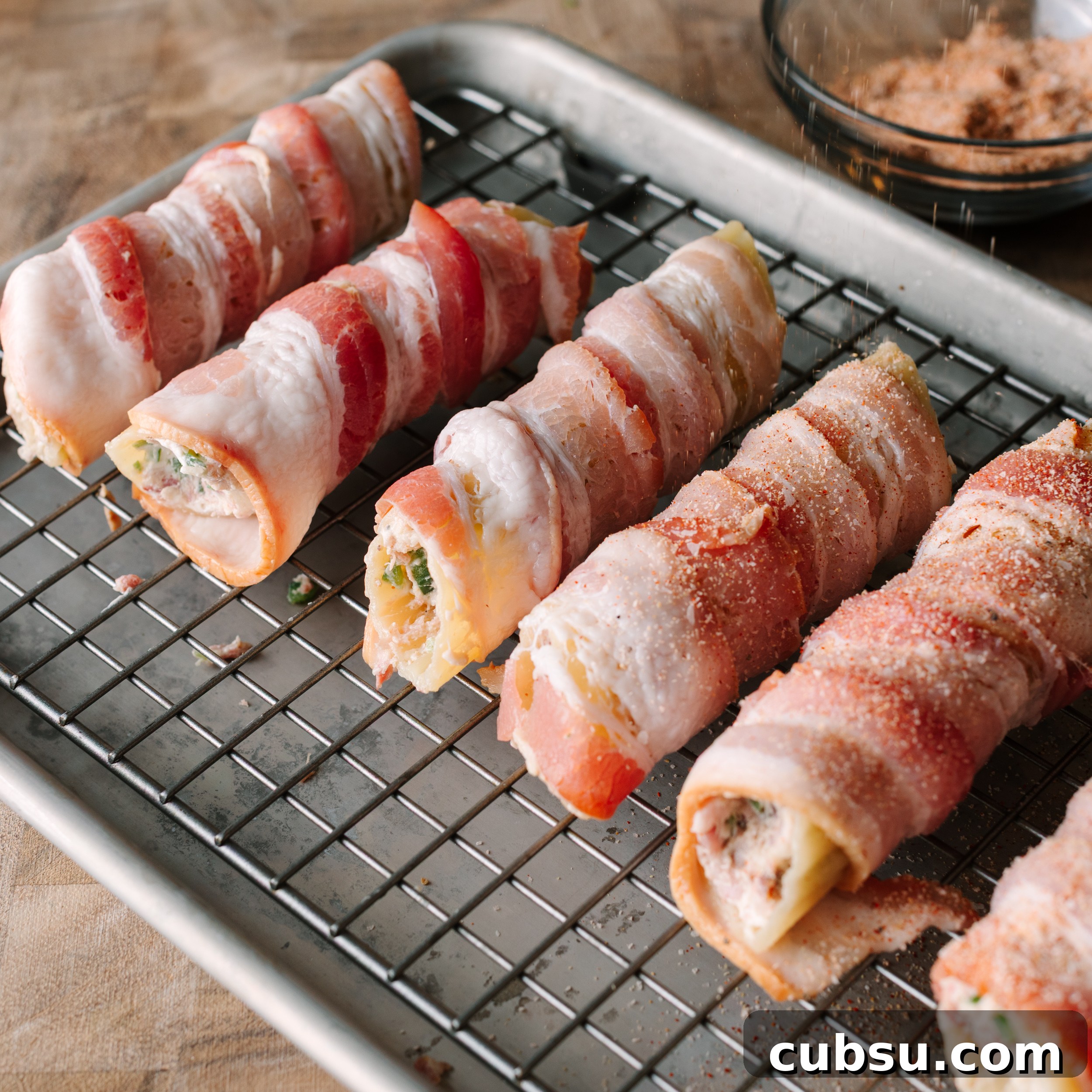 Smoked Shotgun Shells: How They're Made and What to Know 7 Stuffed cannelloni shells wrapped in bacon on a wire rack set over a sheet pan.