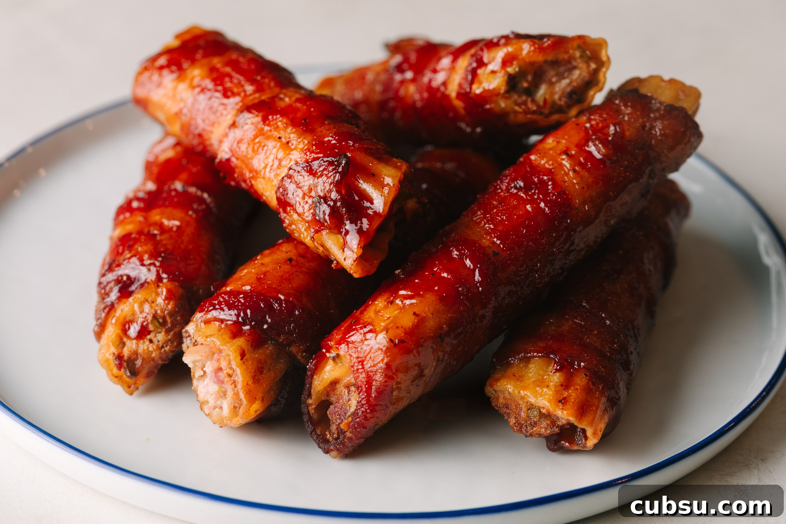 Smoked Shotgun Shells: How They're Made and What to Know 10 Smoked pulled pork shotgun shells on a white plate.