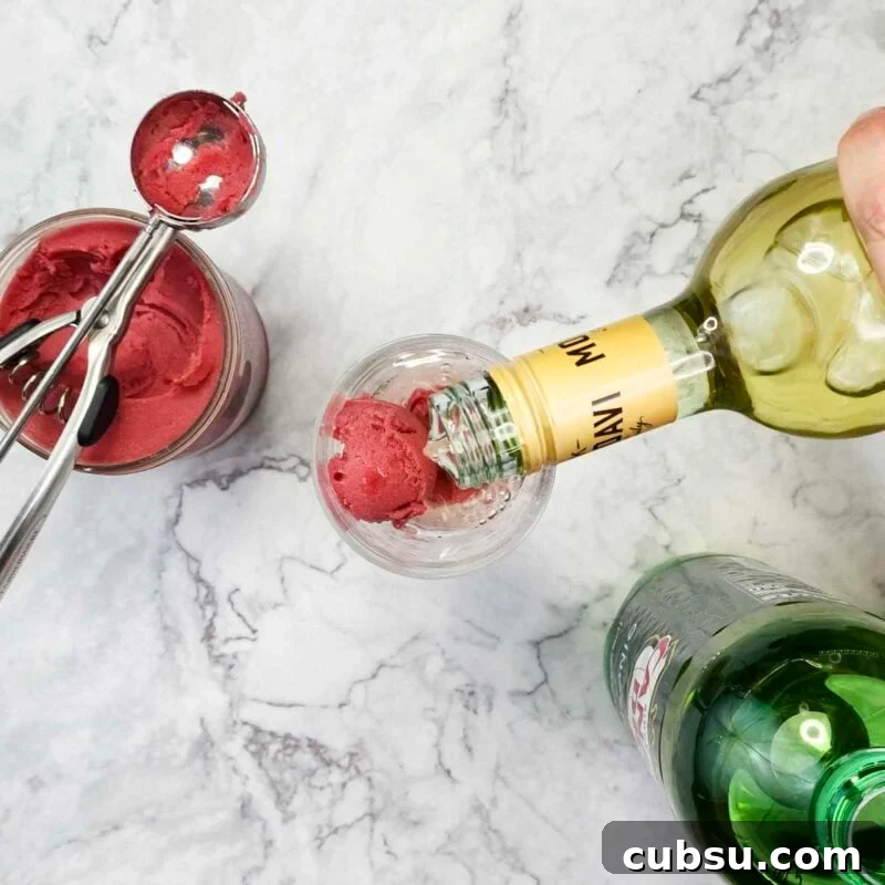 3-Ingredient Raspberry Spritz Cocktail Recipe 4 Process shot: scoop sorbet into a wine glass and pour moscato over it.