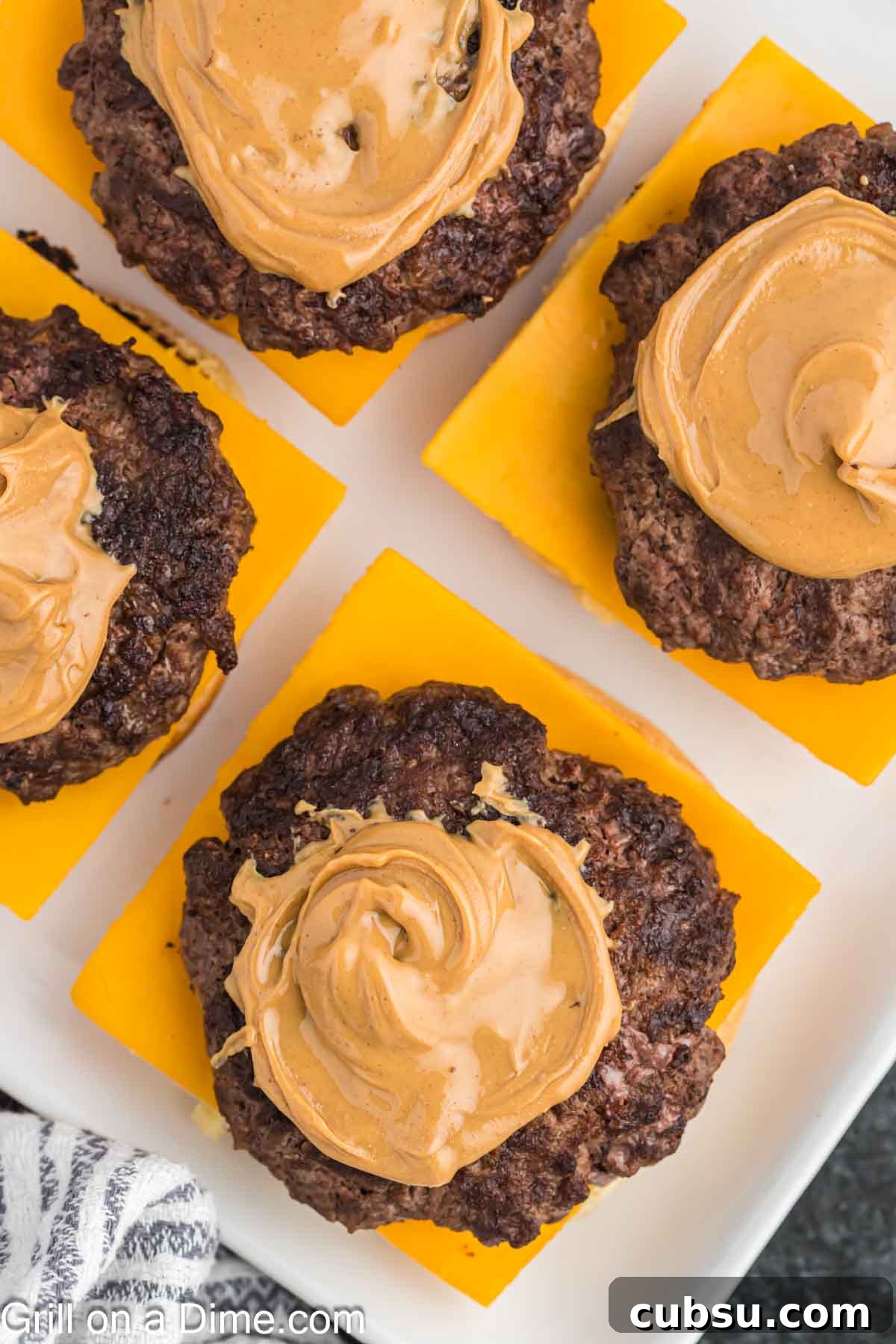 Ground beef patties and topped with peanut butter with a slice of cheese