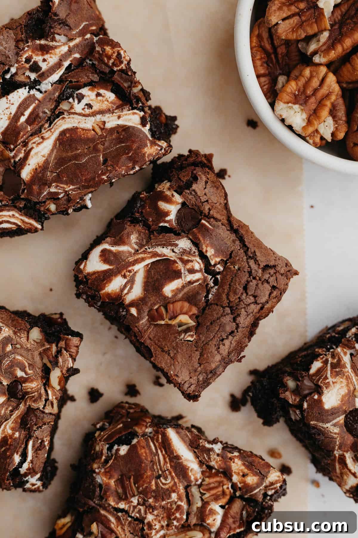 Several marshmallow fluff brownies on light brown parchment paper.
