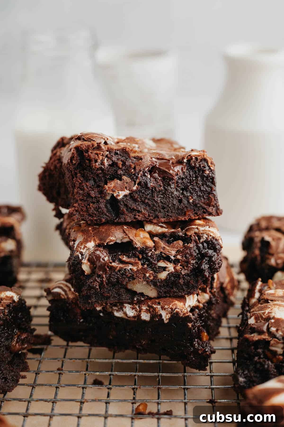 A stack of three brownies with marshmallow fluff on a wire cooling rack.