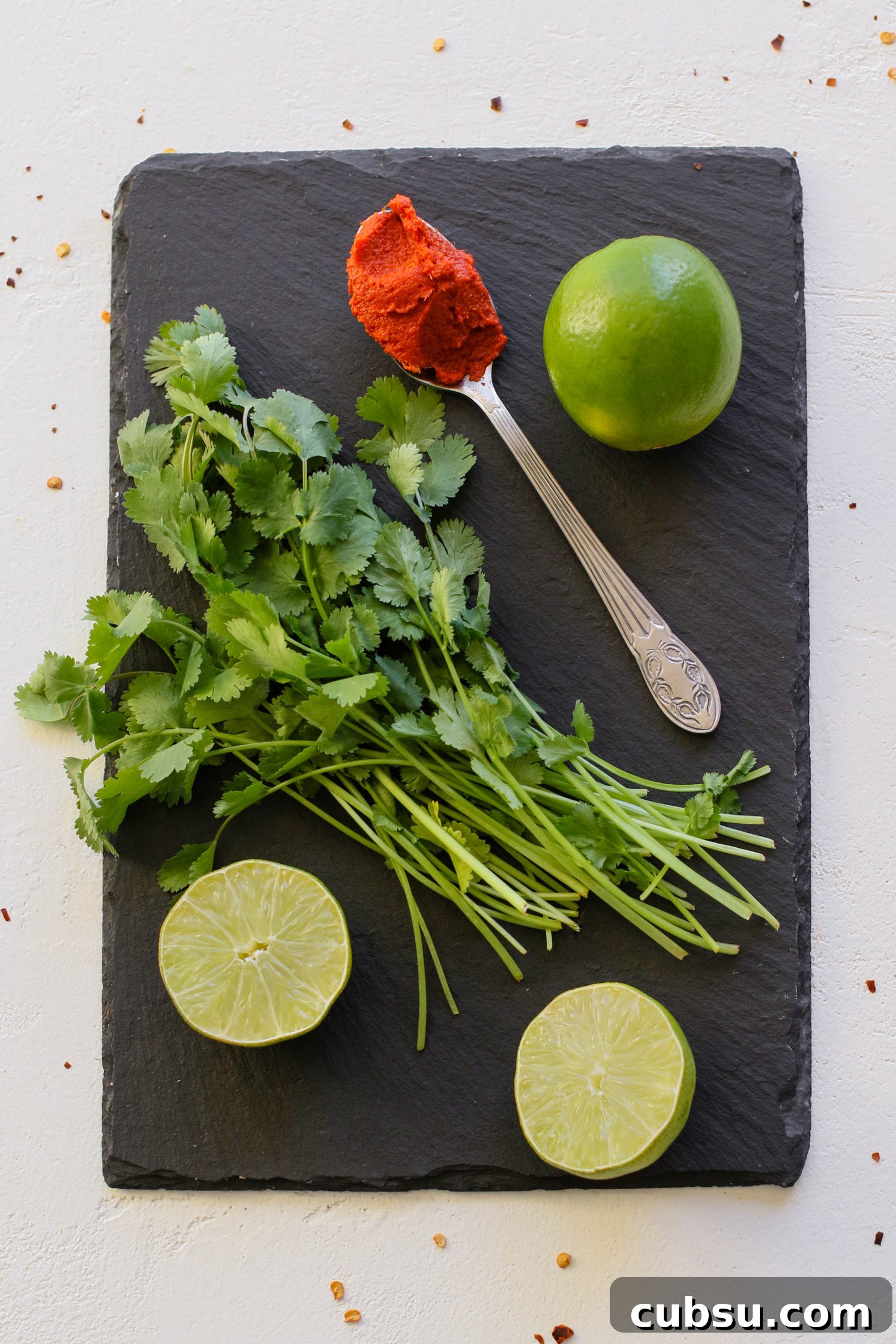lime, curry paste, and cilantro on serving board by Flora & vino
