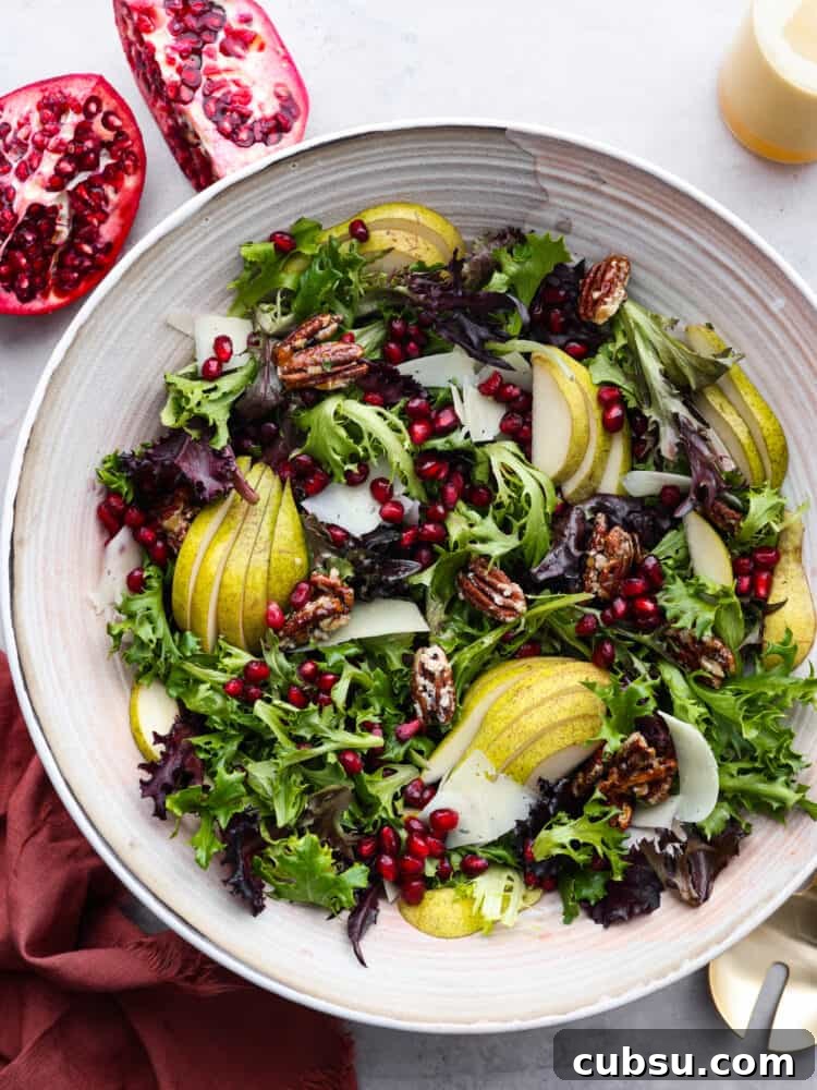 The top view of a pomegranate salad in a white bowl.