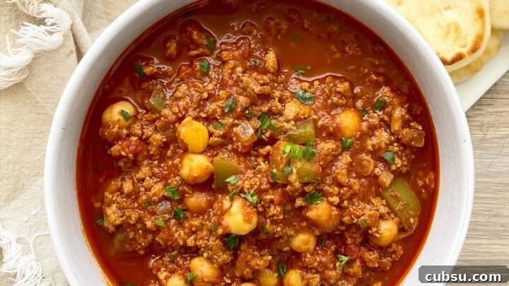indian chili in a bowl with a side of naan