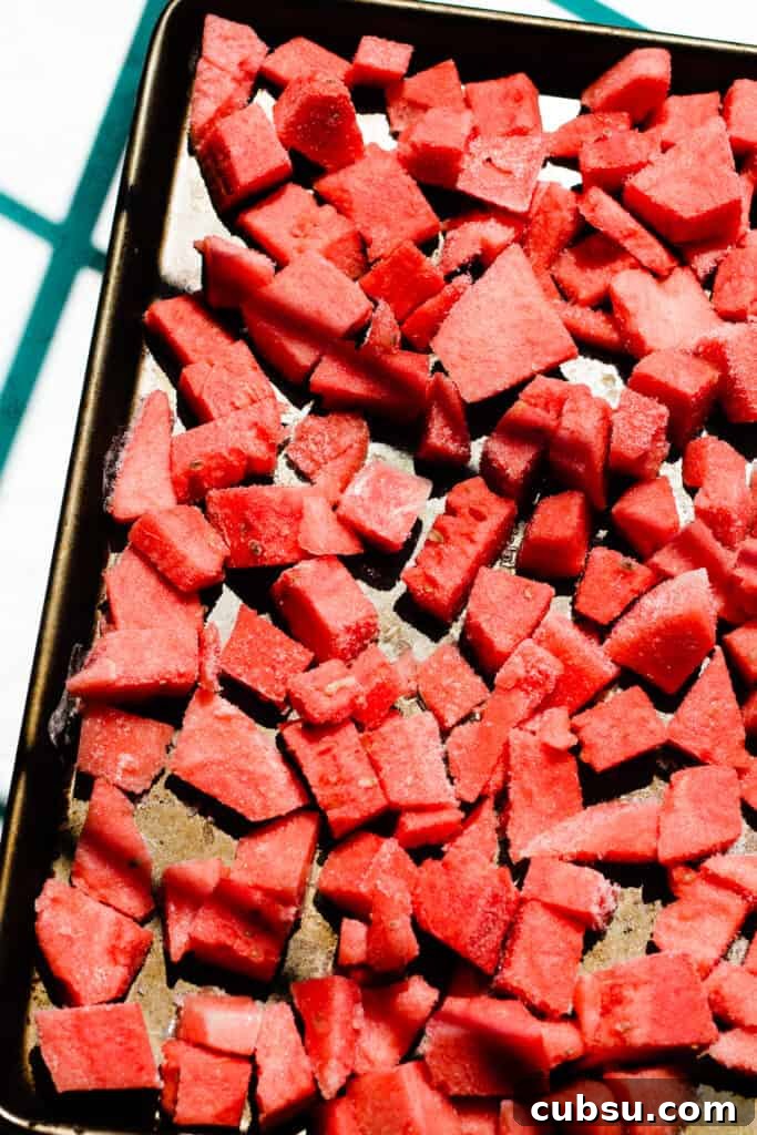 A sheet pan full of frozen watermelon chunks.