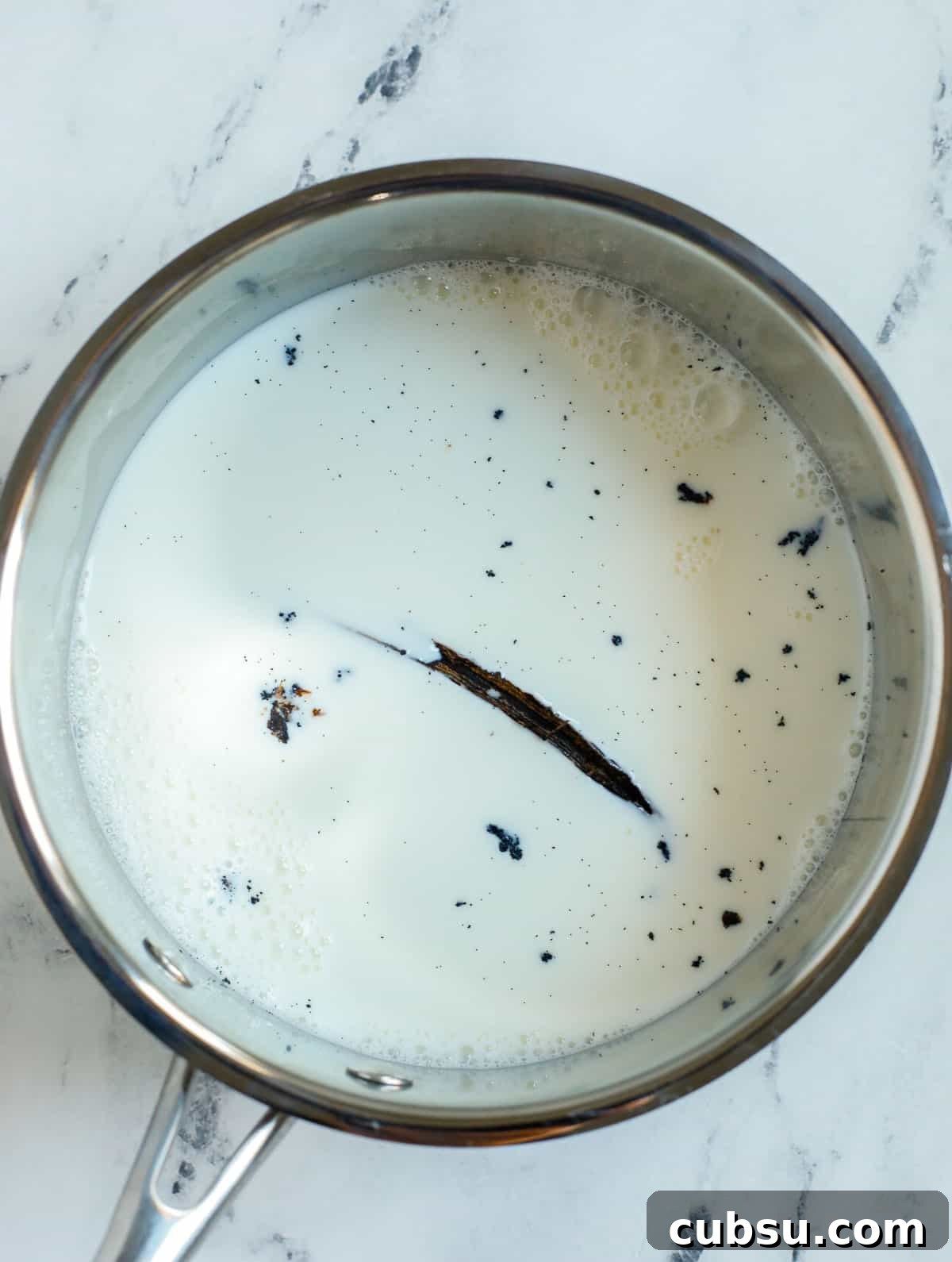 milk in a pot with vanilla bean pod.