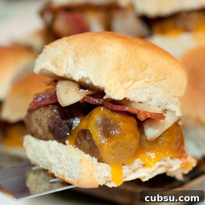 Slider with meatball, cheese, bacon, and onions on a Hawaiian roll.