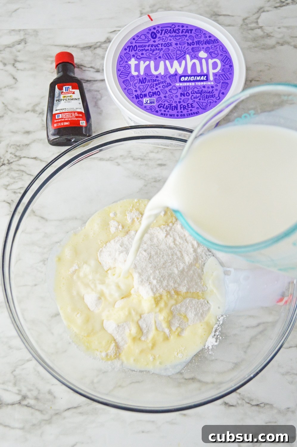 vanilla pudding in a bowl pouring milk in 