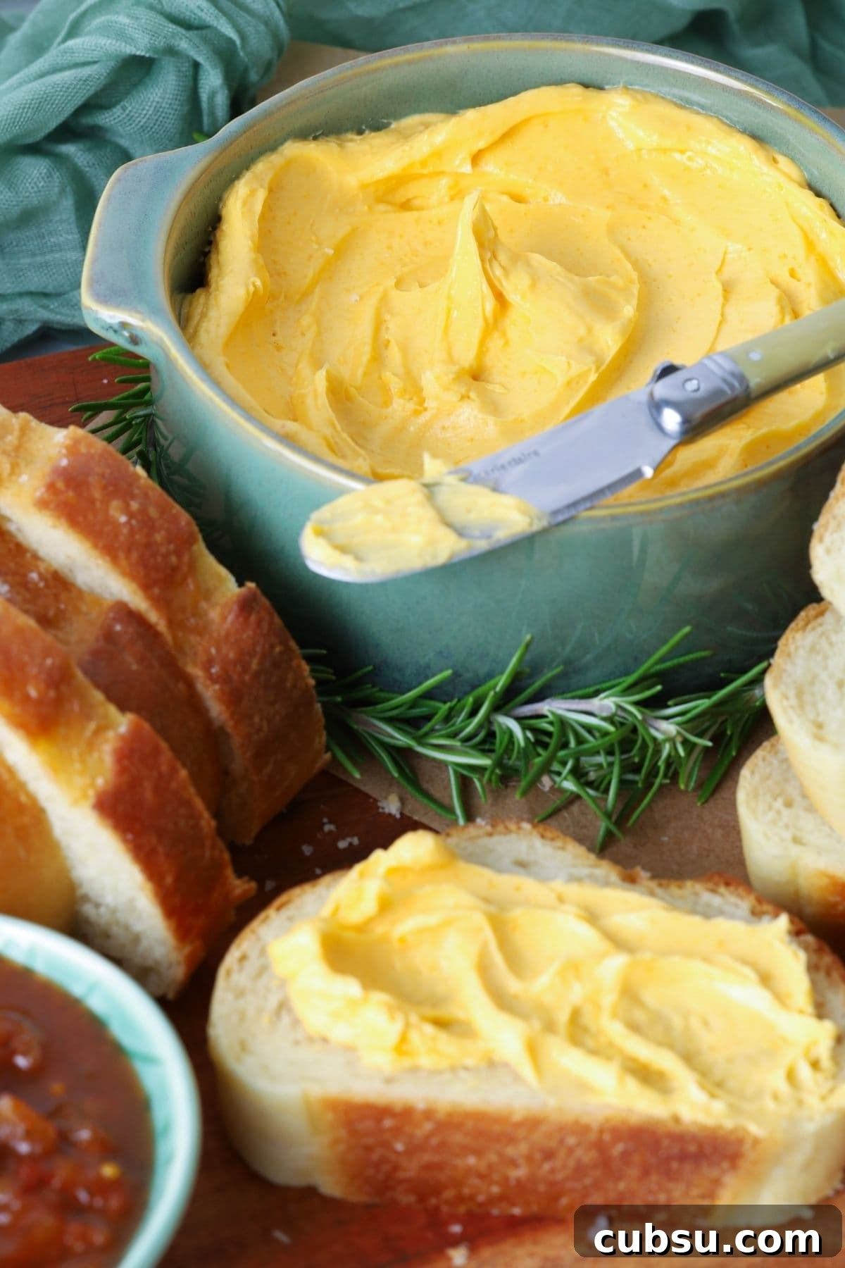 Slice of sourdough bread with cheddar butter spread on top.