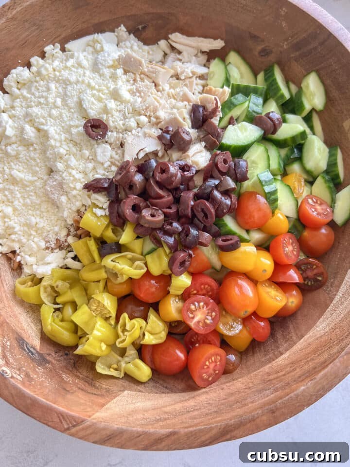 Ingredients for high protein pasta salad in a large wooden bowl, unmixed
