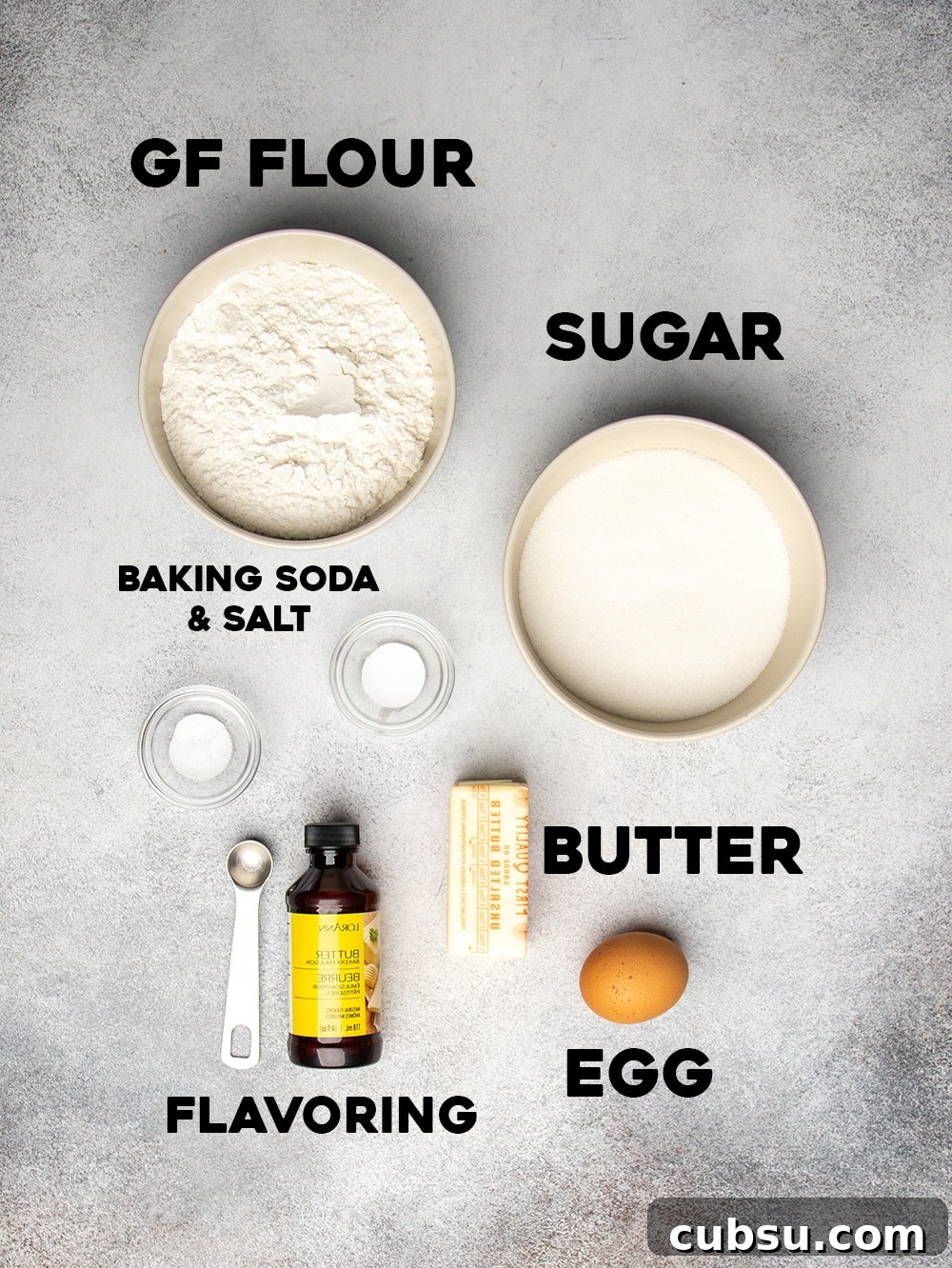 Ingredients for gluten free Crumbl cookies seen from overhead in small bowls with words, gf flour, sugar, baking soda & salt, butter, egg, and flavoring
