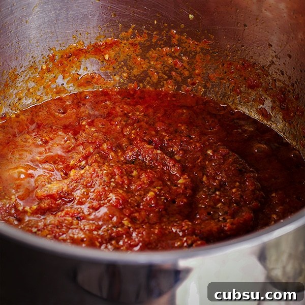 A pot of homemade marinara sauce simmering on the stovetop.