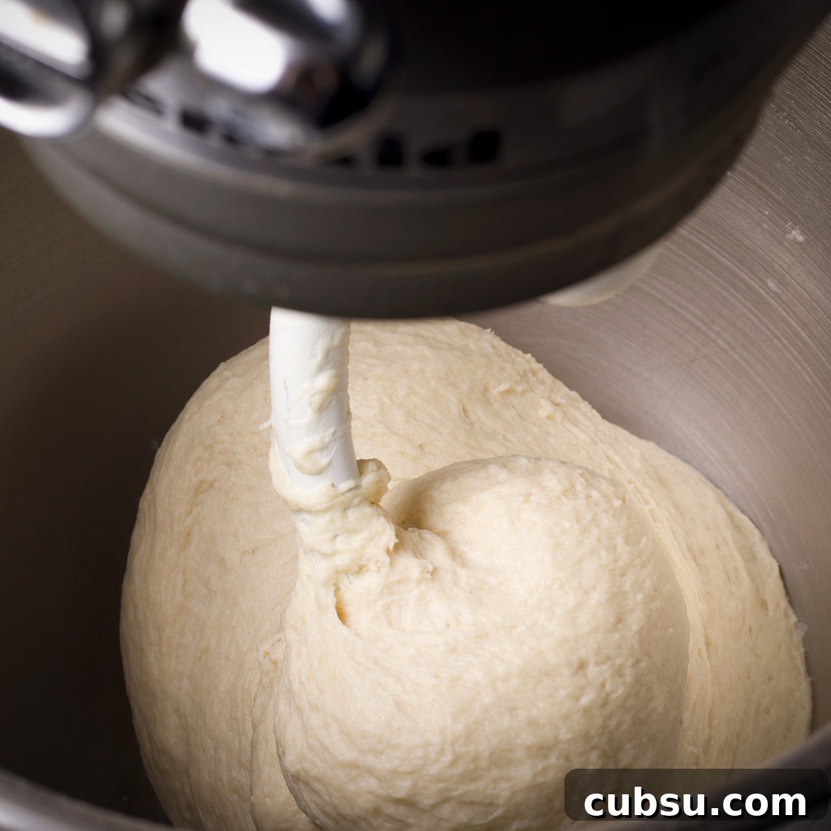 A stand mixer kneading dough until smooth.
