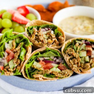 Four sliced veggie wraps with lentils and fresh vegetables in a blue dish
