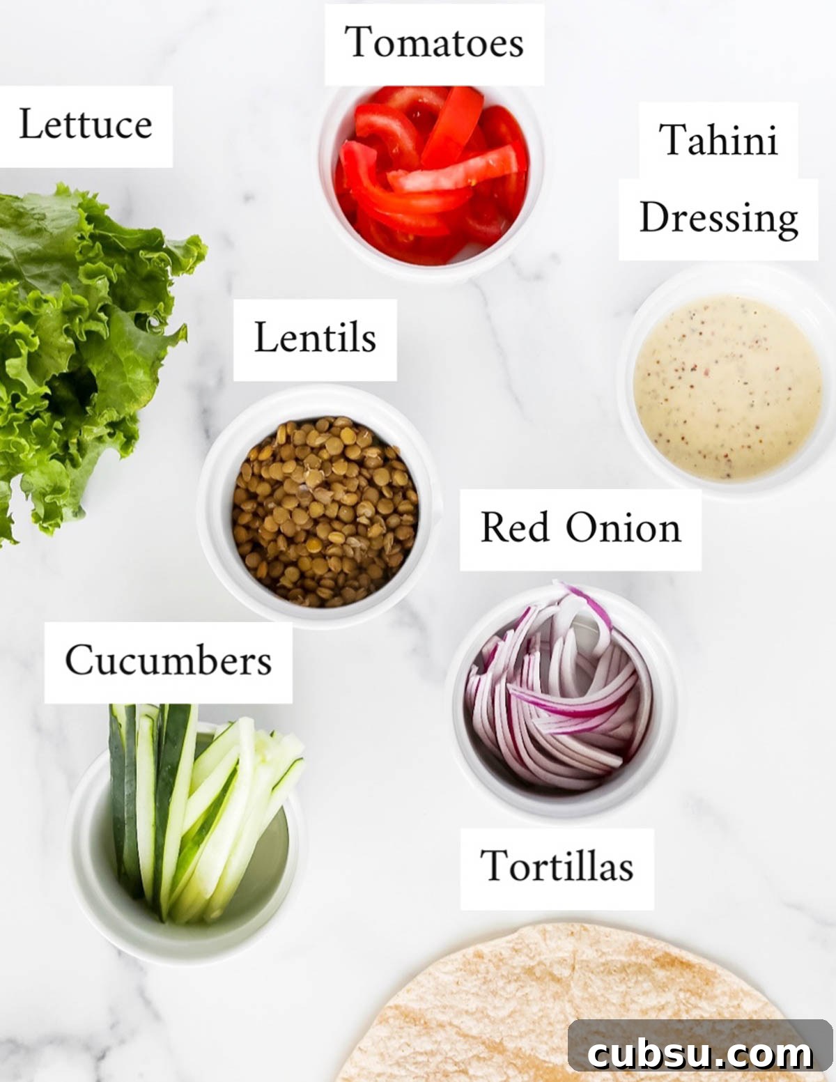 Labeled ingredients including: lettuce, tomatoes, tahini dressing, lentils, red onion, cucumbers, tortillas
