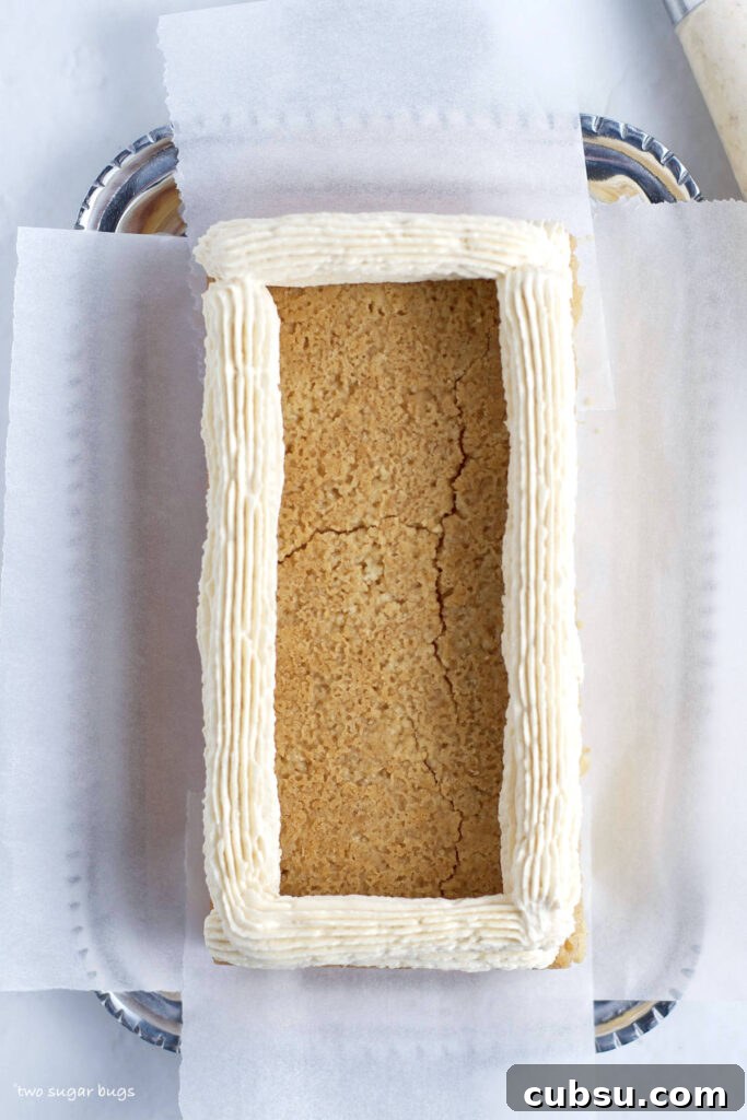 buttercream dam piped around edge of cake
